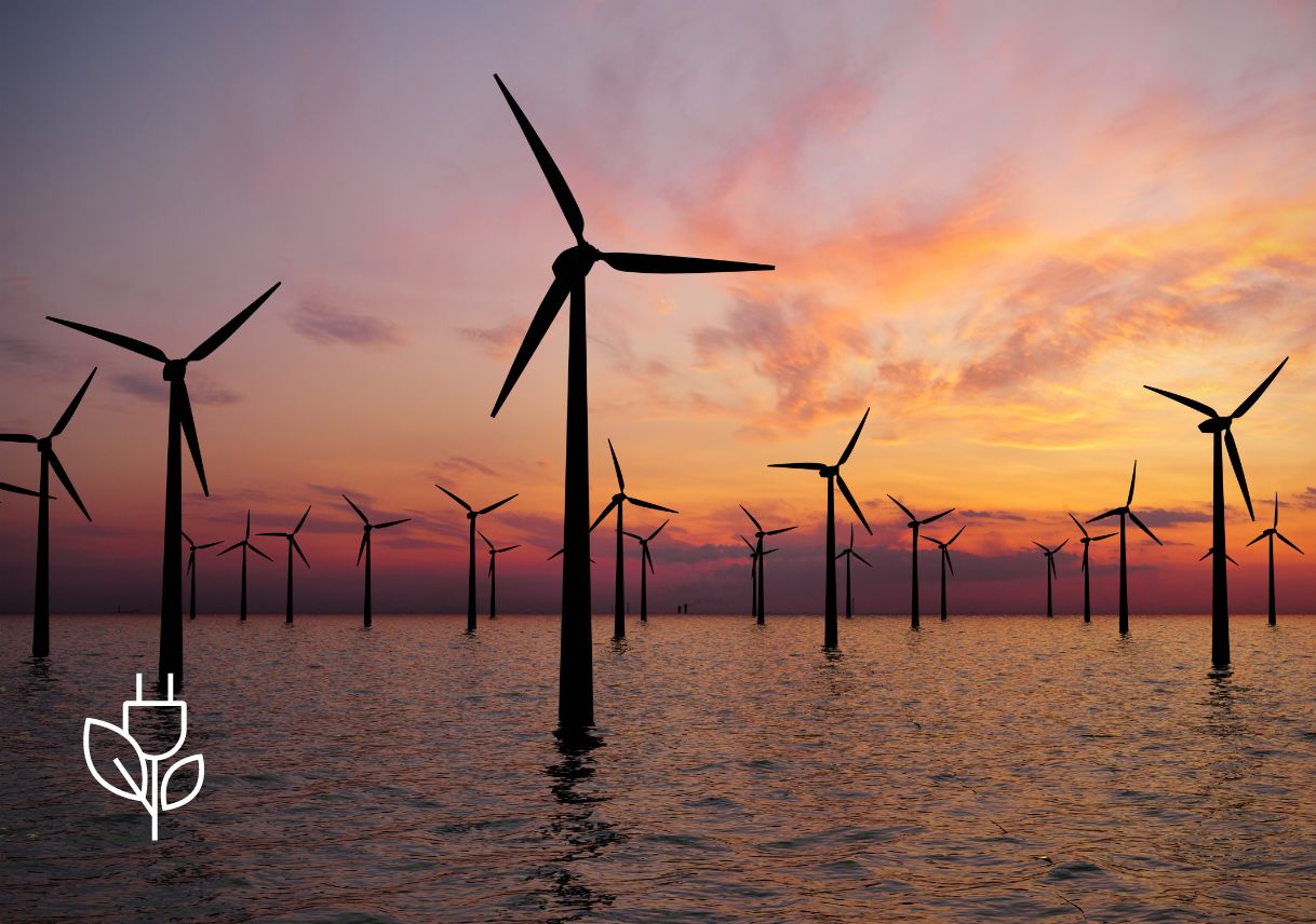 Wind turbines surrounded by water at sunset
